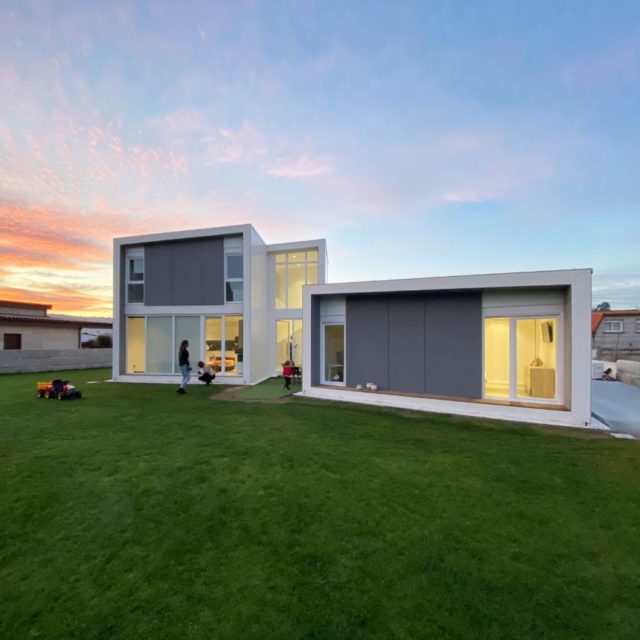 casa modular de diseño con personas jugando en el jardín